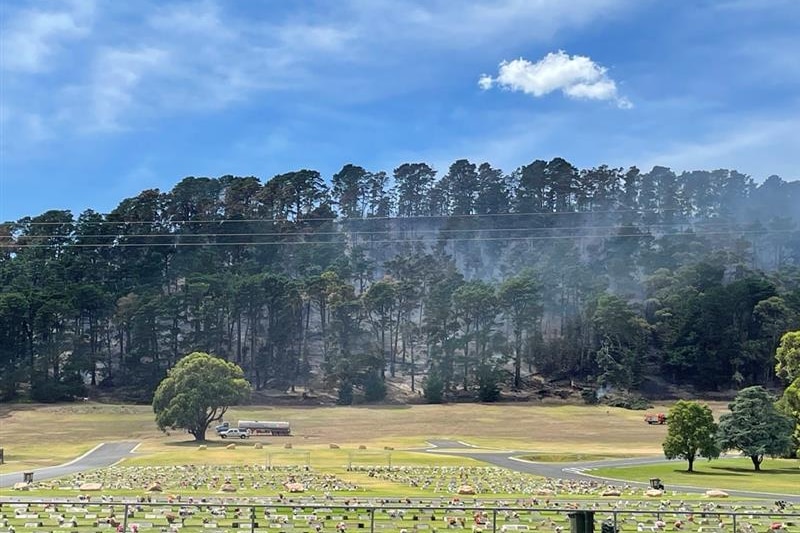 Fire at the rear of a cemetery in trees