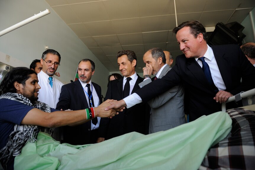 French president Nicolas Sarkozy (c) and Britain's prime minister David Cameron (r) visit patients at a Tripoli hospital