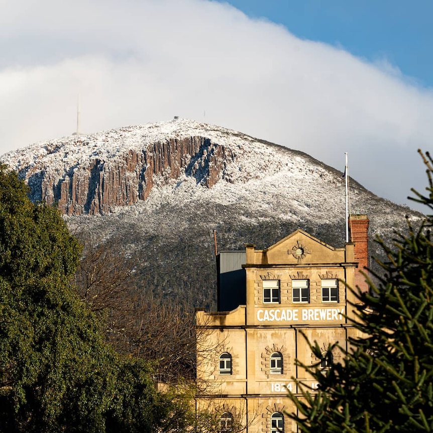 Mt Wellington covered in snow, with the Cascade Brewery in the foreground.