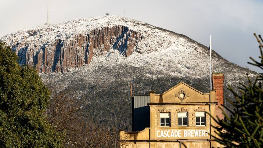 Mt Wellington covered in snow, with the Cascade Brewery in the foreground.