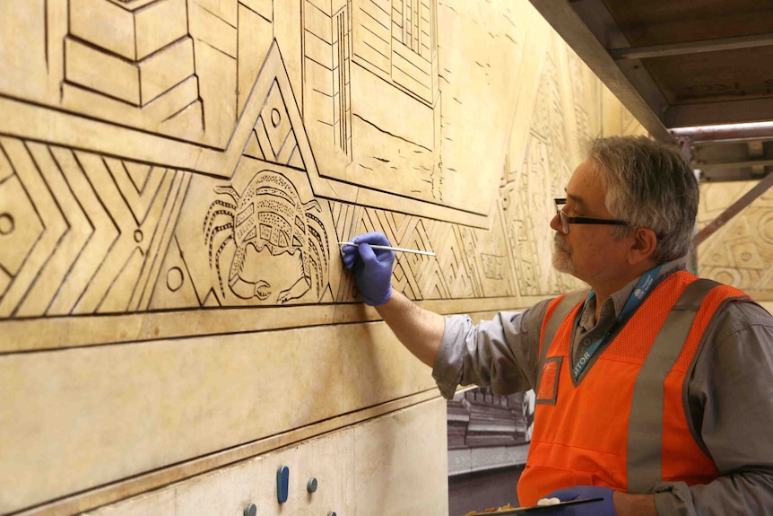 Man working on the train mural.