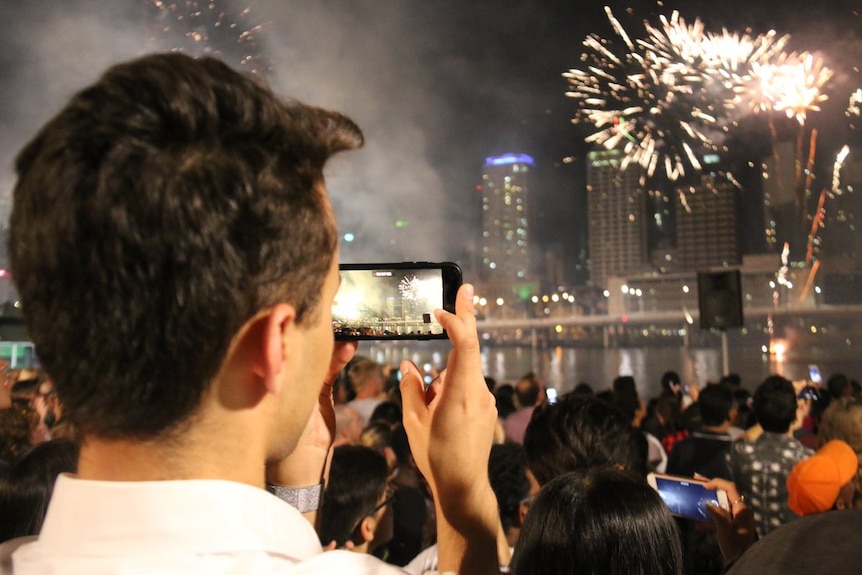 A reveller watches fireworks in Brisbane