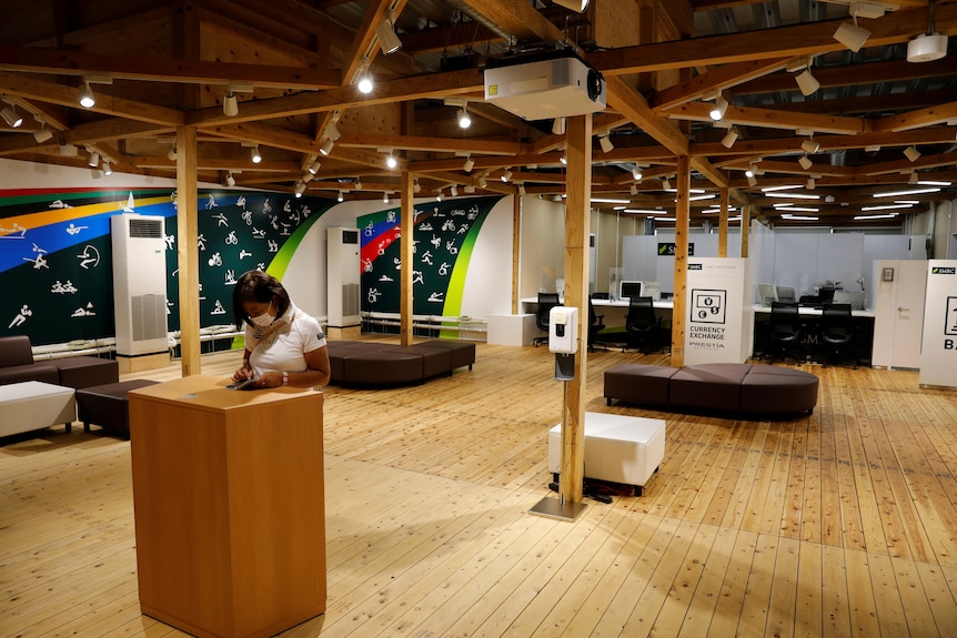 A bank at the village plaza of the Tokyo 2020 Olympic Village with timber beams across ceiling and minimal furnihture.