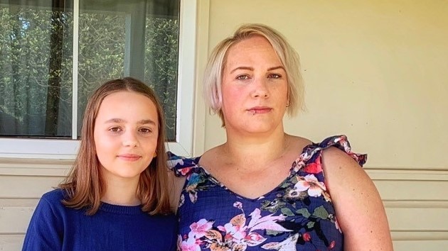 Natalie looks a little serious, wearing a floral dress, while Celeste smiles.