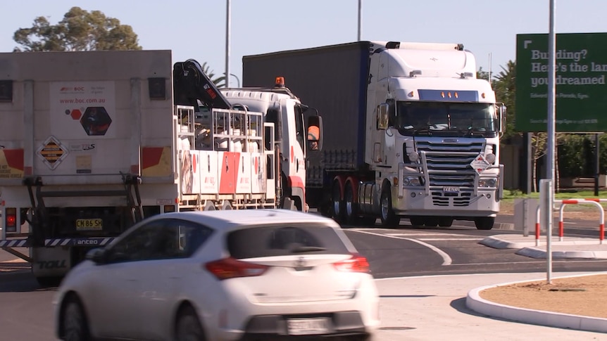 Trucks and a car going around a roundabout