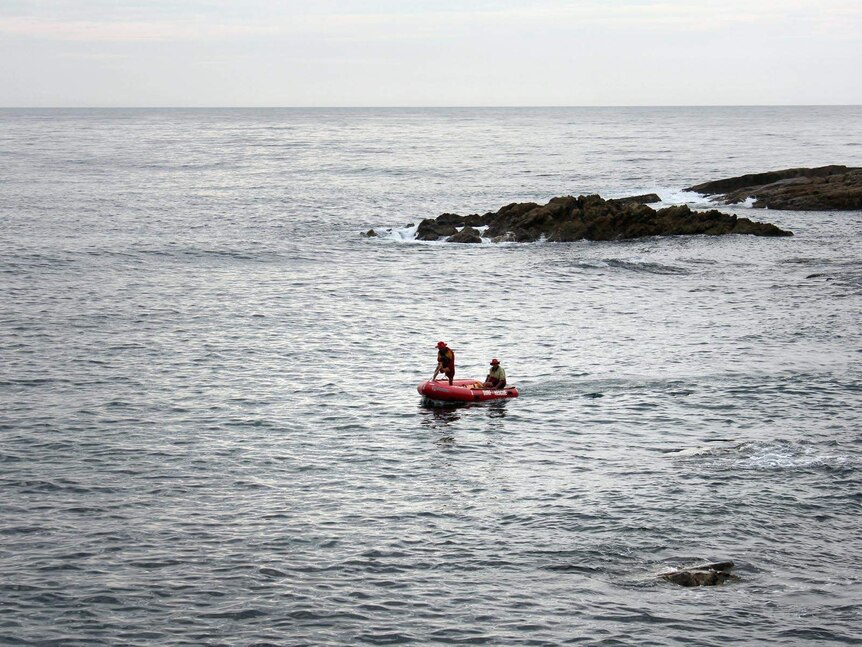 A surf rescue IRB searches the area where a woman was killed by a shark at Tathra.