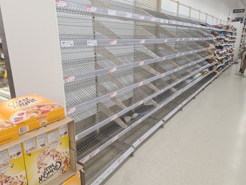 a bread shelf in a grocery store is empty