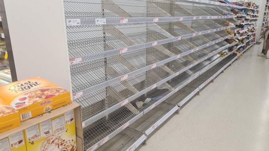 a bread shelf in a grocery store is empty 