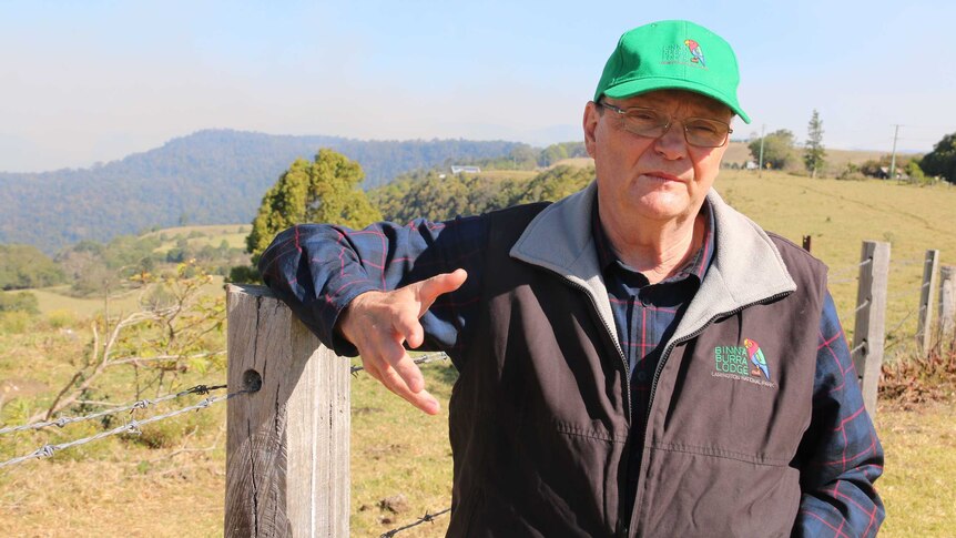 Binna Burra lodge chairman Steve Noakes stands next to a barb wire fence in the country.