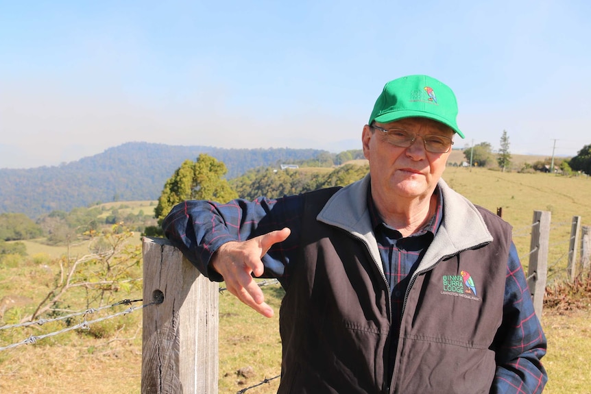 Binna Burra lodge chairman Steve Noakes stands next to a barb wire fence in the country.