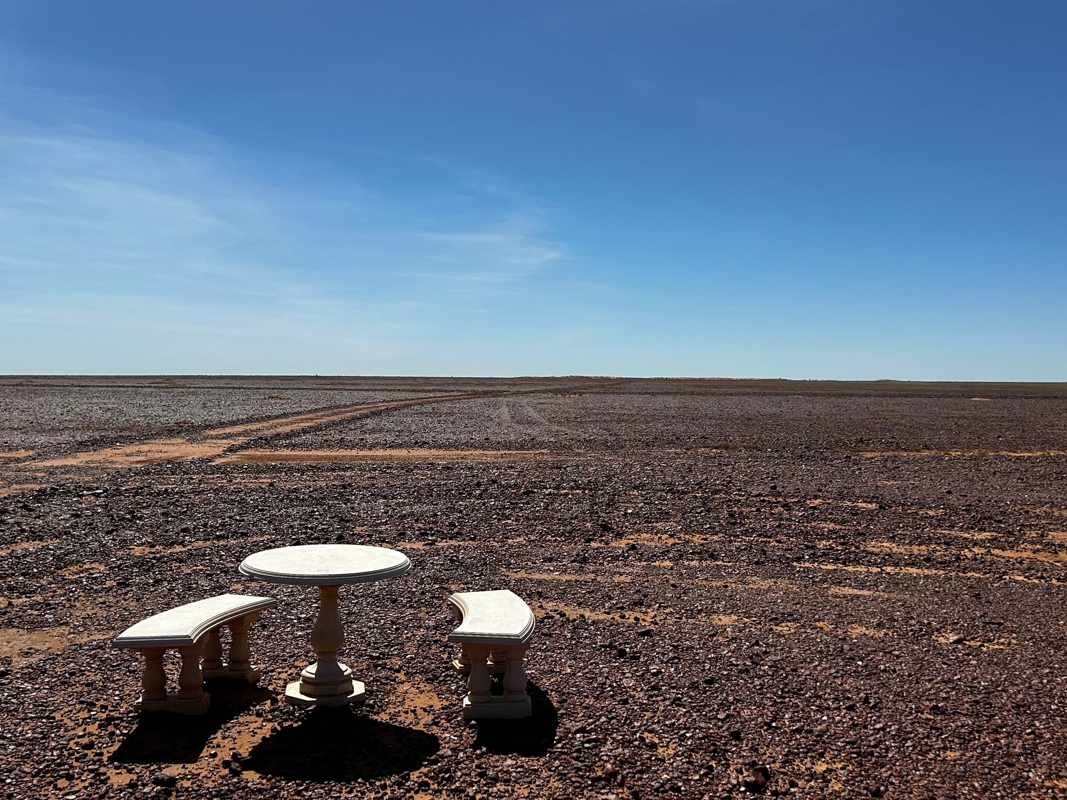 A table and some chairs in the desert.