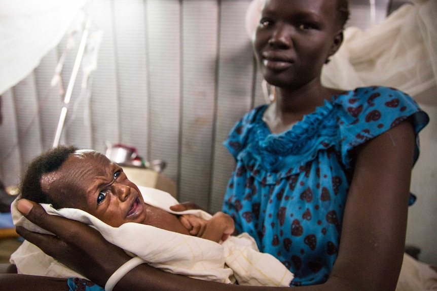 Nyakena holds one of her children at a clinic in Juba, South Sudan. Nyakena fled fighting while pregnant with twins.