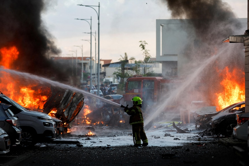 A firefighter extinguishes fire on a street in Ashkelon