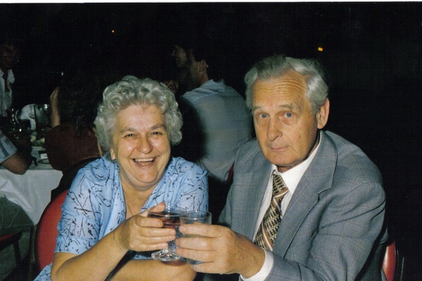 An old film photograph of Hen and Rose Nieman at a round dinner table at a function, with drinks in their hands.