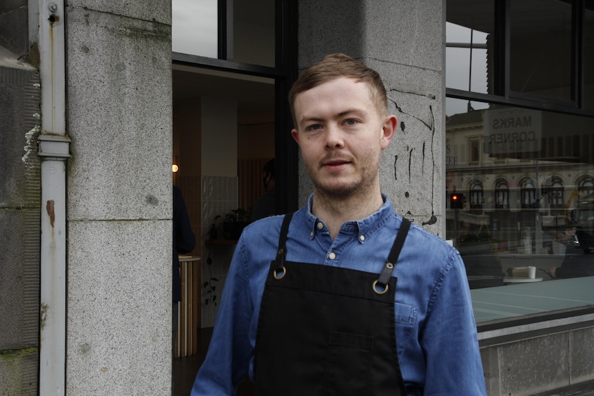 A man in a blue shirt wearing an apron