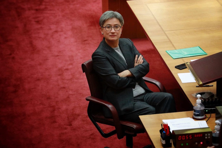 Penny Wong est assise au Sénat, les bras croisés