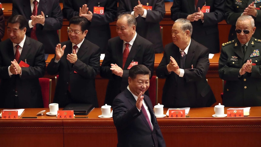 Chinese President Xi Jinping waves as he is clapped by his supporters at China's 19th Party Congress.