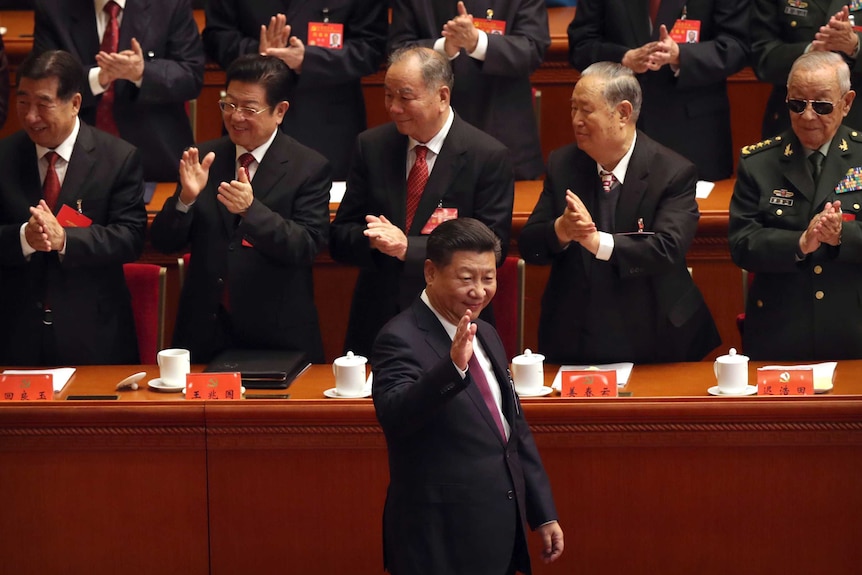 Chinese President Xi Jinping waves as he is clapped by his supporters at China's 19th Party Congress.