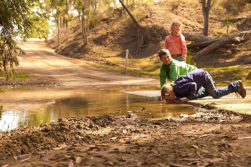 The McArthur children at a stream on their property