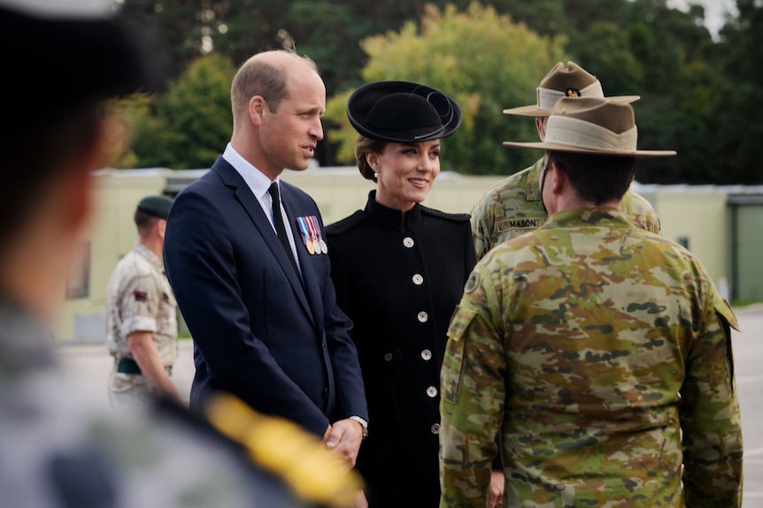 Prince William and Princess Catherine talking to people in Australian army uniforms