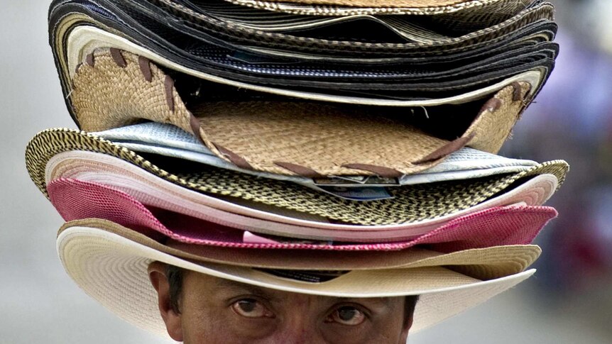 A peddler sells hats in a Colombian street.