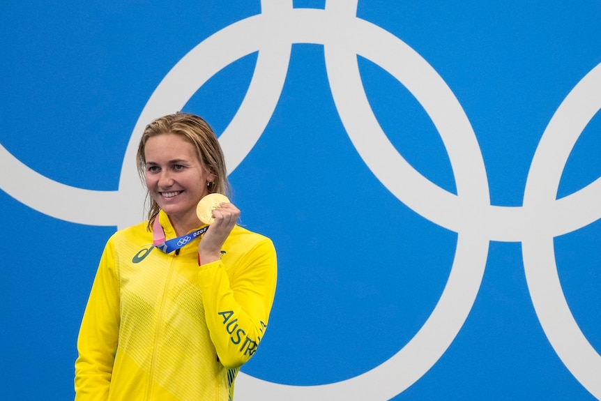 Ariarne Titmus stands with her gold medal after winning the women's 200m freestyle final at the Tokyo Olympics.