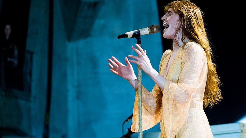 Florence Welch of Florence + The Machine sings into a microphone at the Sidney Myer Music Bowl in Melbourne