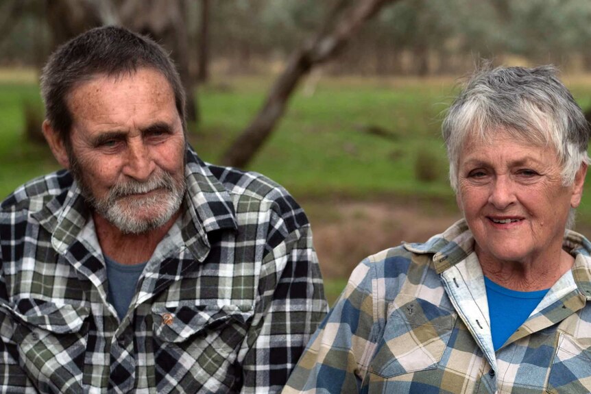 a couple wearing checked flannel shirts fill the frame