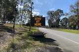 An electronic road sign with the words "stay at home".