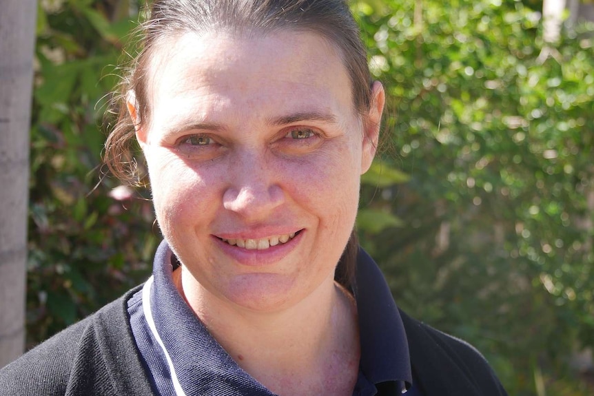 Close up of a woman in her early 40s looking at the camera and smiling