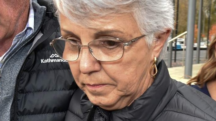 A grey-haired woman wearing glasses and a black puffer jacket next to a white-haired man in a black puffer jacket.