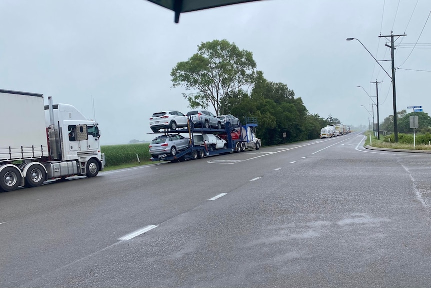 Trucks lined up along the side of the road. 