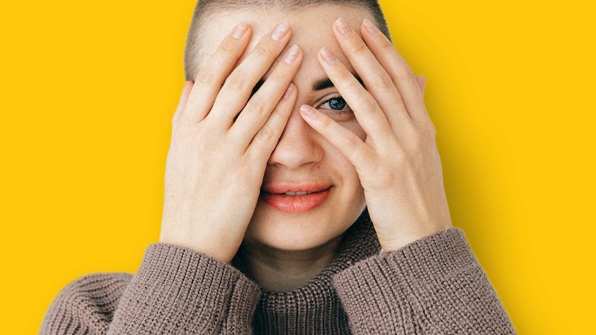 Woman covers her face with her hands for story on isolating during coronavirus pandemic.