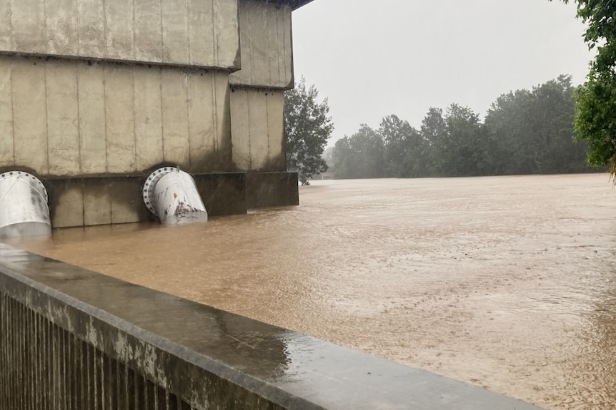 A levee barely holding back floodwaters.