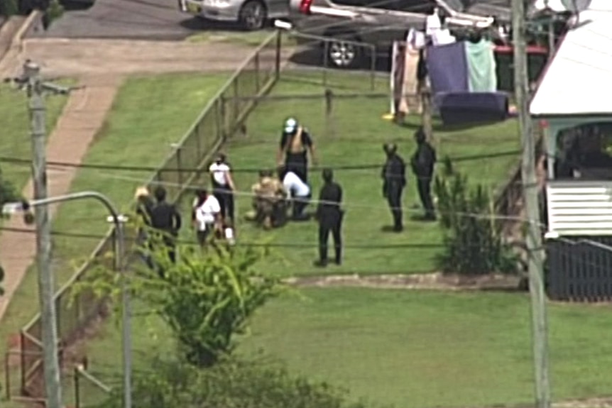 Aerial image of police arresting a man in the front yard of a suburban property