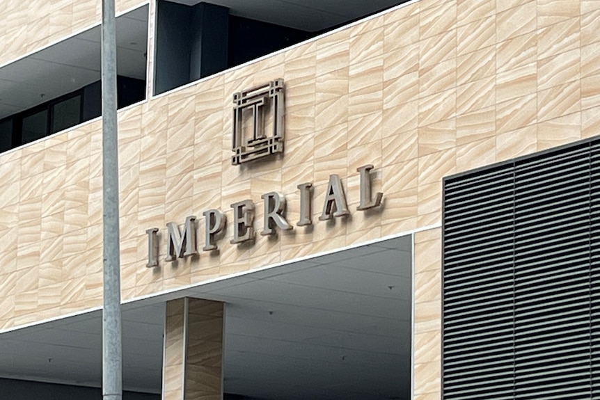 Imperial Towers sign on two 22-storey sandy coloured  on apartment high rises in Parramatta street in front