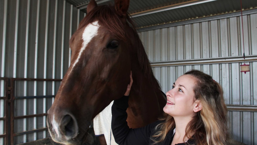 A close up of a girl with a horse.