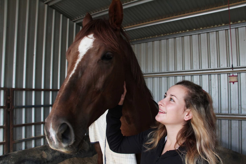 A close up of a girl with a horse.