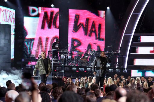 A sign reading "No wall, no ban" can be seen behind A Tribe Called Quest.