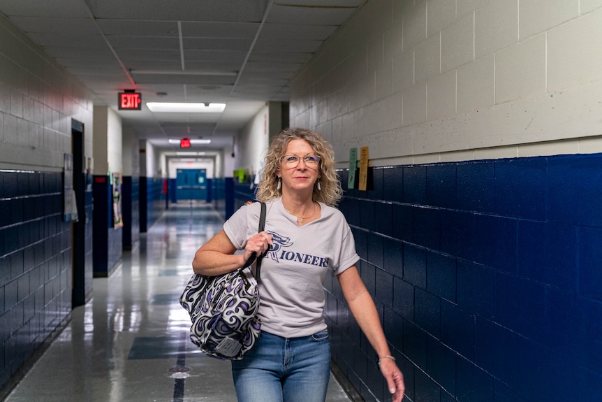 Anita hatcher walks down a hallway in school.