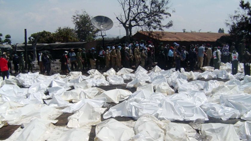UN Peacekeepers and medics stand beside the bagged bodies of victims of an oil tanker explosion