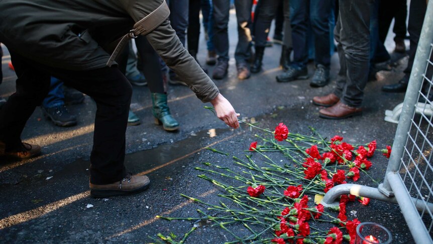 People leave flowers for the victims outside a nightclub which was attacked by a gunman overnight in Istanbul