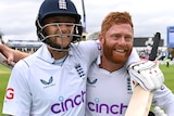 Joe Root and Jonny Bairstow smile and carry their gear off the field, arm in arm