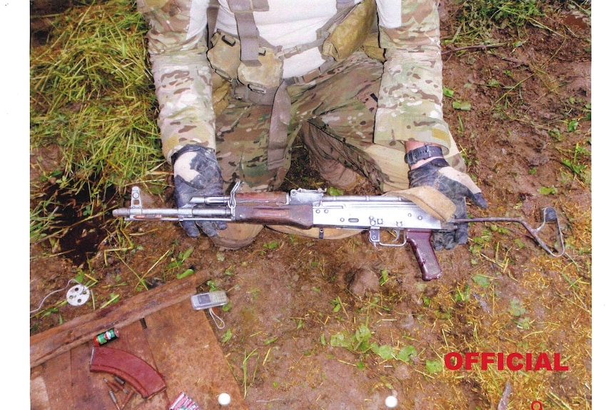 Un soldat tenant une arme trouvée dans un bunker