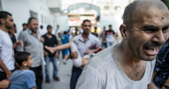 The father of a Palestinian girl screams after she was injured in rocket fire.