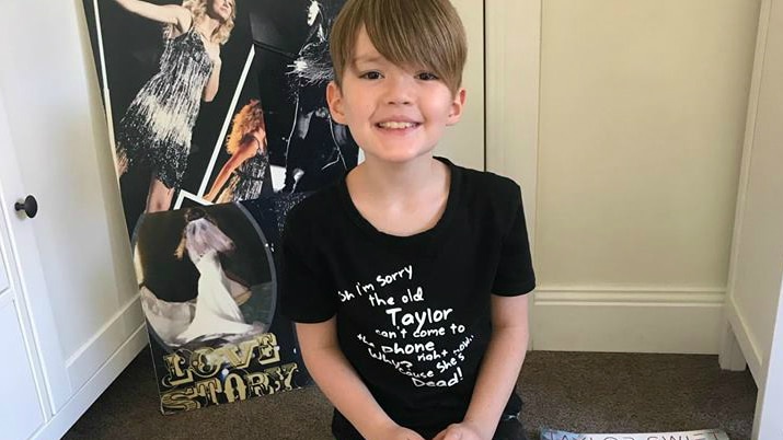 Eight-year-old Fletcher sits among his Taylor Swift memorabilia.
