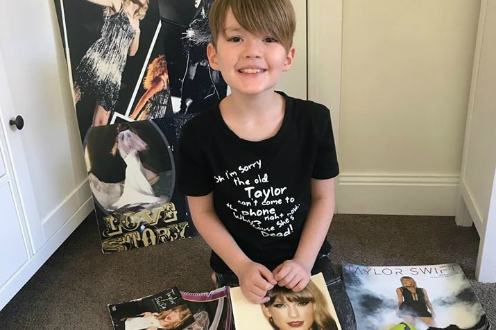 Eight-year-old Fletcher sits among his Taylor Swift memorabilia.