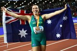Mackenzie Little holds Aus flag and wears medal smiling at camera