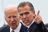 Joe Biden stands behind Hunter Biden, who is pointing at something. A black car is in the background.