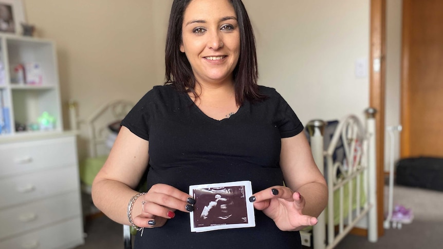 a pregnant woman holding an ultrasound